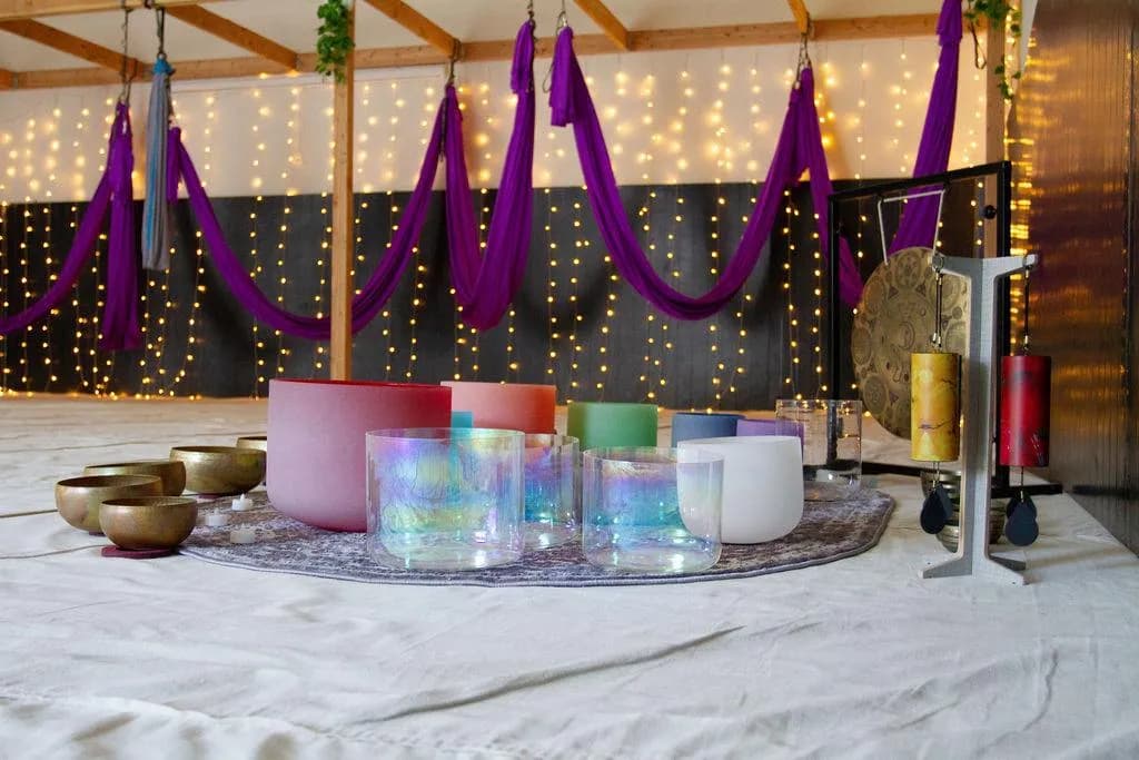 Colorful crystal singing bowls before the silk hammocks